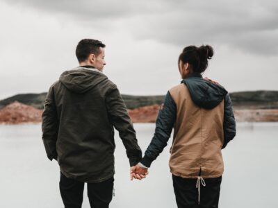 couple holding hands at lake