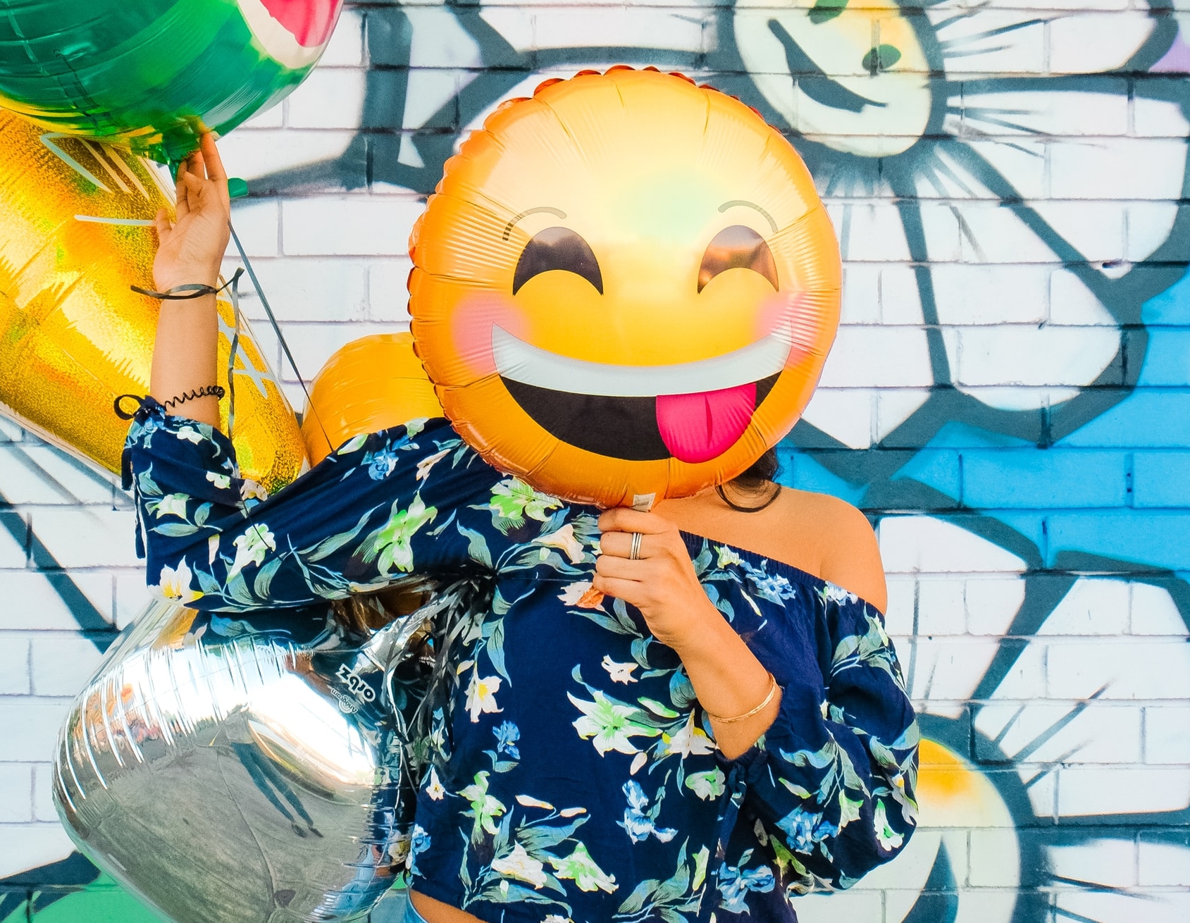 woman holding smiley face balloon