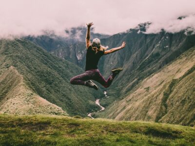 woman jumping atop mountain