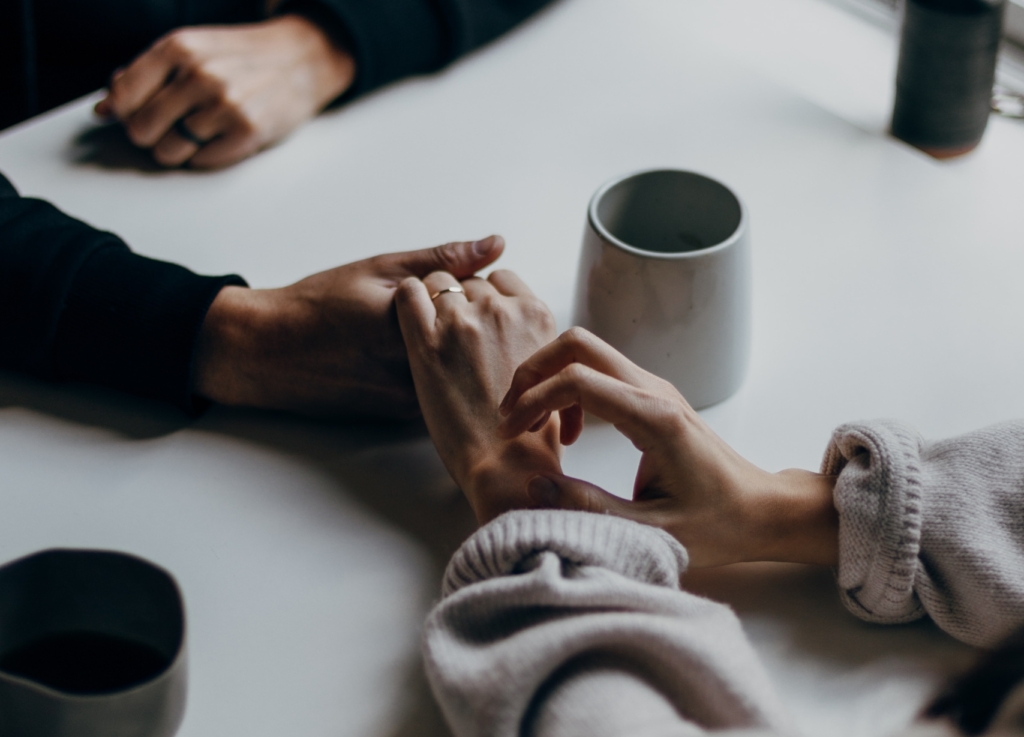 couple holding hands across table